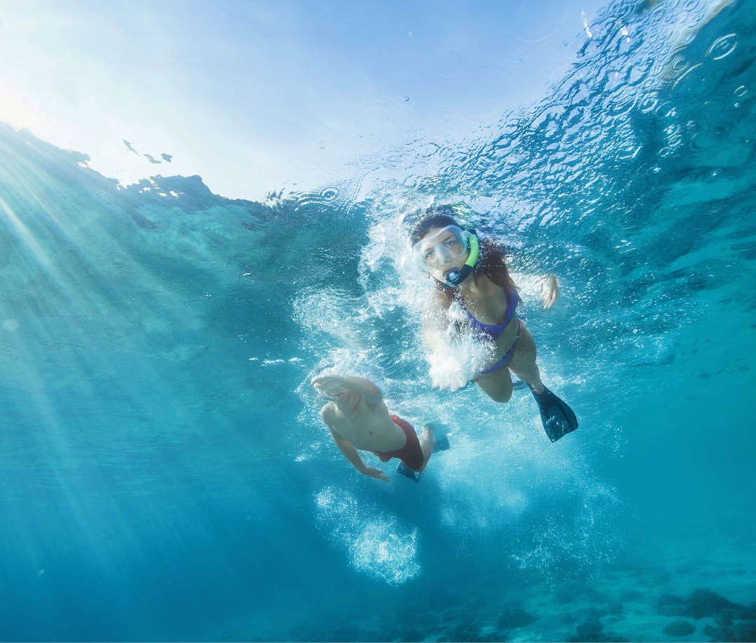 Snorkeling adventure. Best friends. Young man and woman, diving into the sea. Underwater turquoise lagoon. Happy teenage couple swimming, joy into the crystal clear sea. Mediterranean beach. Summer sea romance.