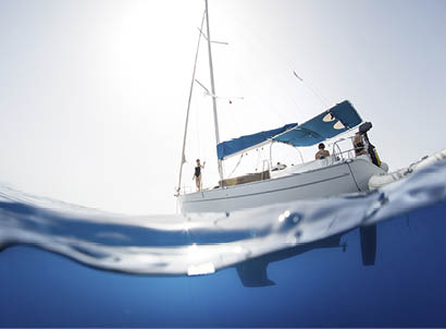 Split shot of the sail boat on surface and its underwater view