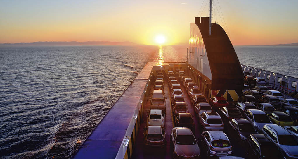 Ferry with cars on the sea at sunset