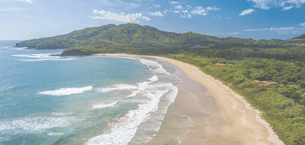 Costa Rica Best Beach: Playa Grande, Guanacaste - Aerial Drone View of Tropical White Sand Beach - Famous Surfing Location with big Waves, lush green Mountains, blue Sky and beautiful Landscape 