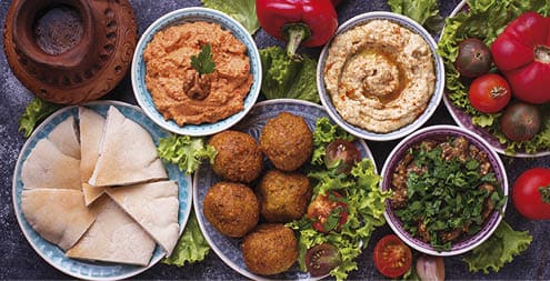 Selection of Middle eastern or Arabic dishes  Falafel, hummus, pita and  muhammara  Top view