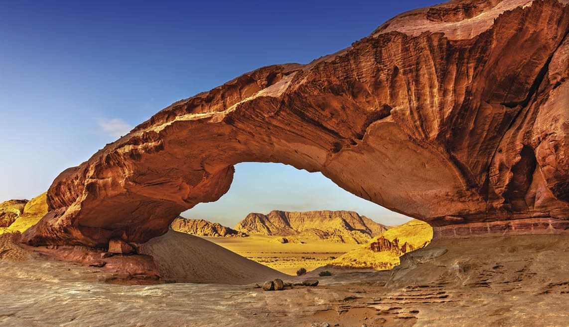 View through a rock arch in the desert of Wadi Rum, Jordan, Middle East