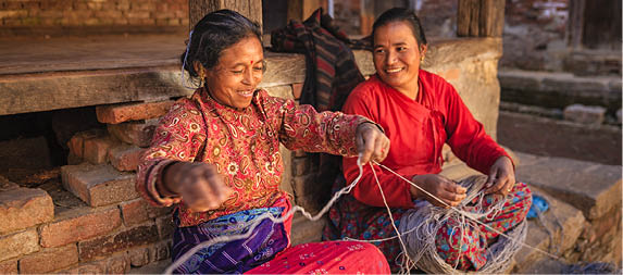 Nepali women spinning a wool in front of the house. Bhaktapur in Kathmandu valley. Nepal.http://bem.2be.pl/IS/nepal_380.jpg