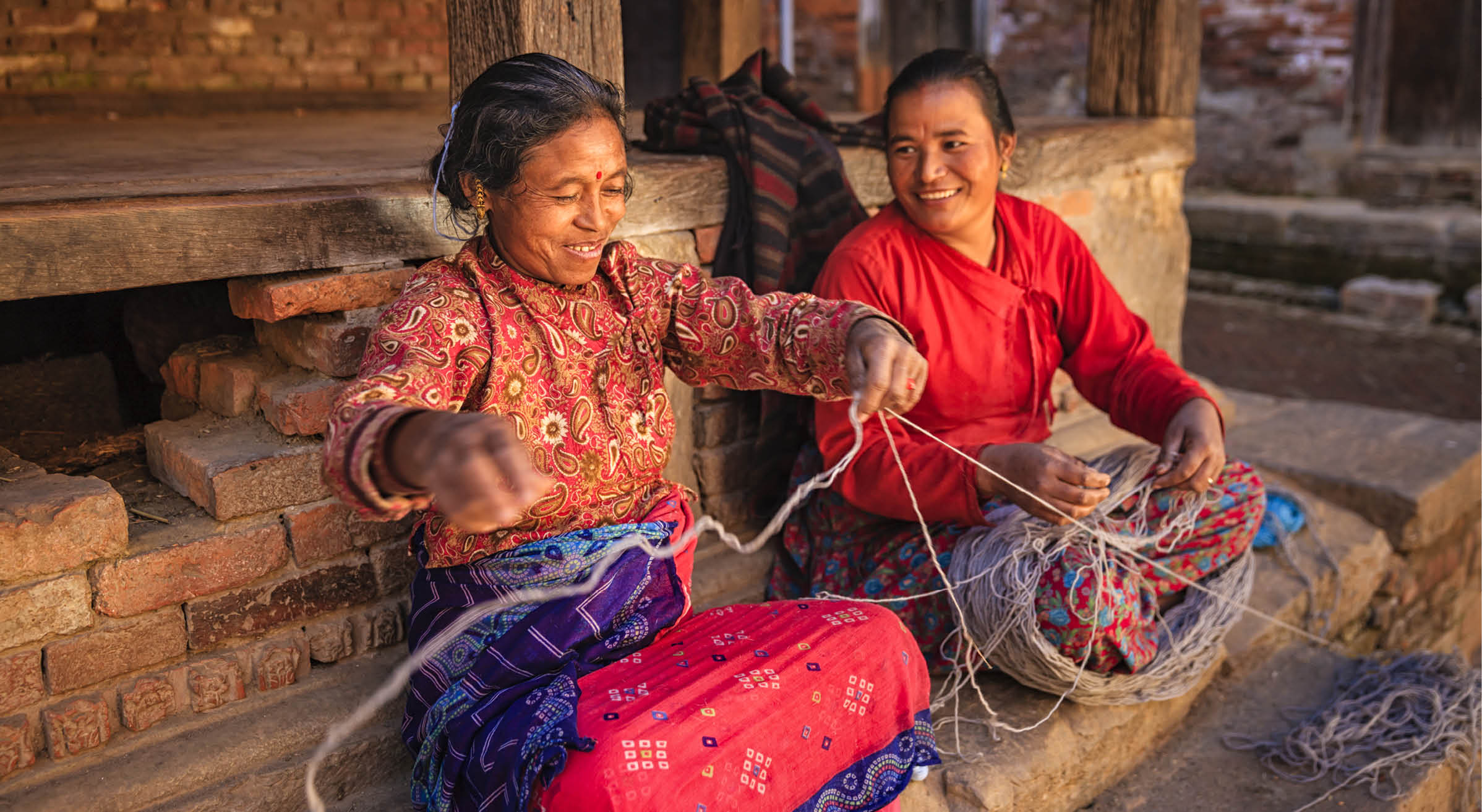 Nepali women spinning a wool in front of the house. Bhaktapur in Kathmandu valley. Nepal.http://bem.2be.pl/IS/nepal_380.jpg