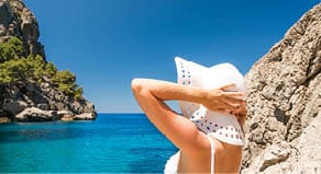 Young woman in white hat looking at sea