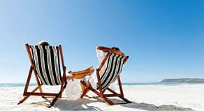 peaceful summer beach couple sitting and relaxing enjoying the sunshine on a pristine coastline