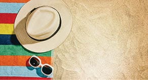 Top view of sandy beach with towel frame and summer accessories  Background with copy space and visible sand texture  Right border made of towel