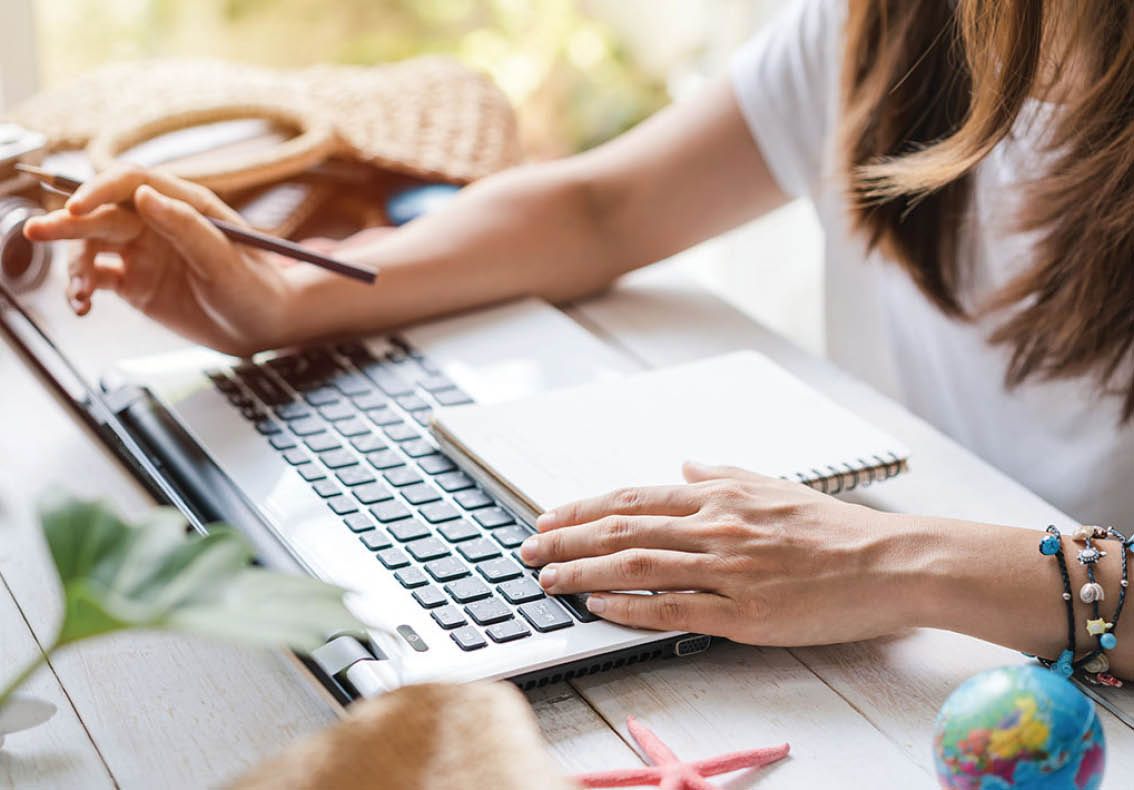 Young women planning summer vacation trip and searching information or booking hotel on smart phone and laptop, Travel concept
