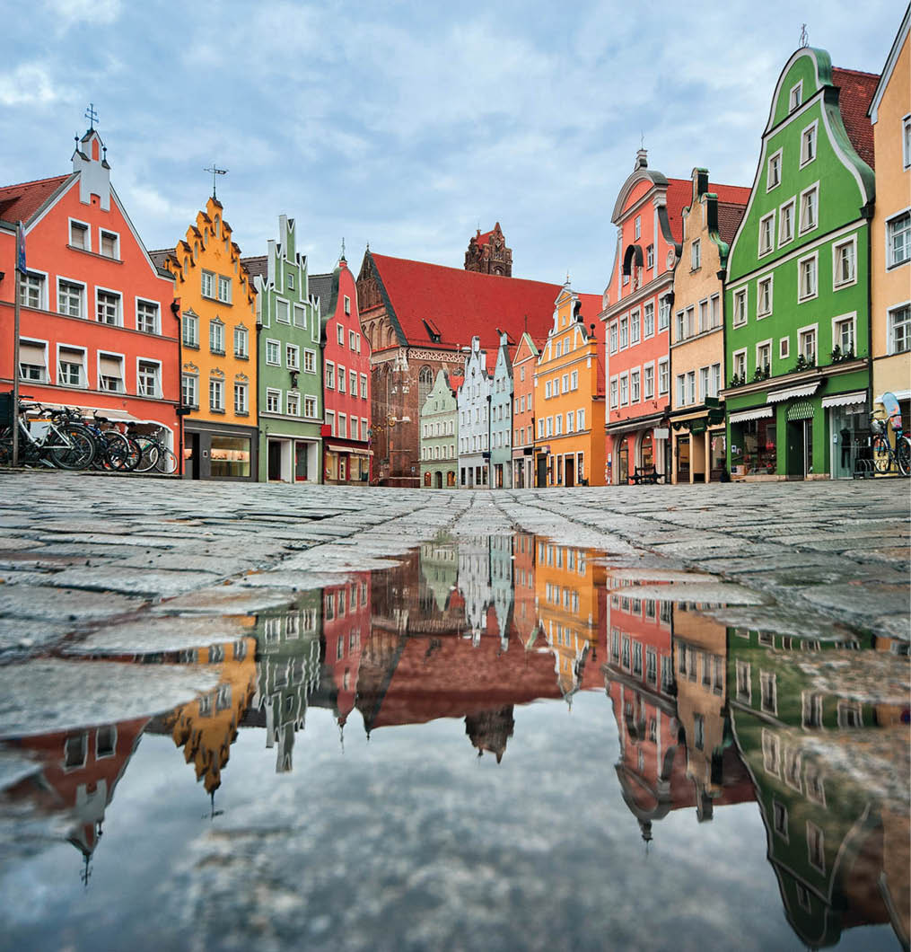 Picturesque old gothic houses reflecting in a puddle in a german city near Munich