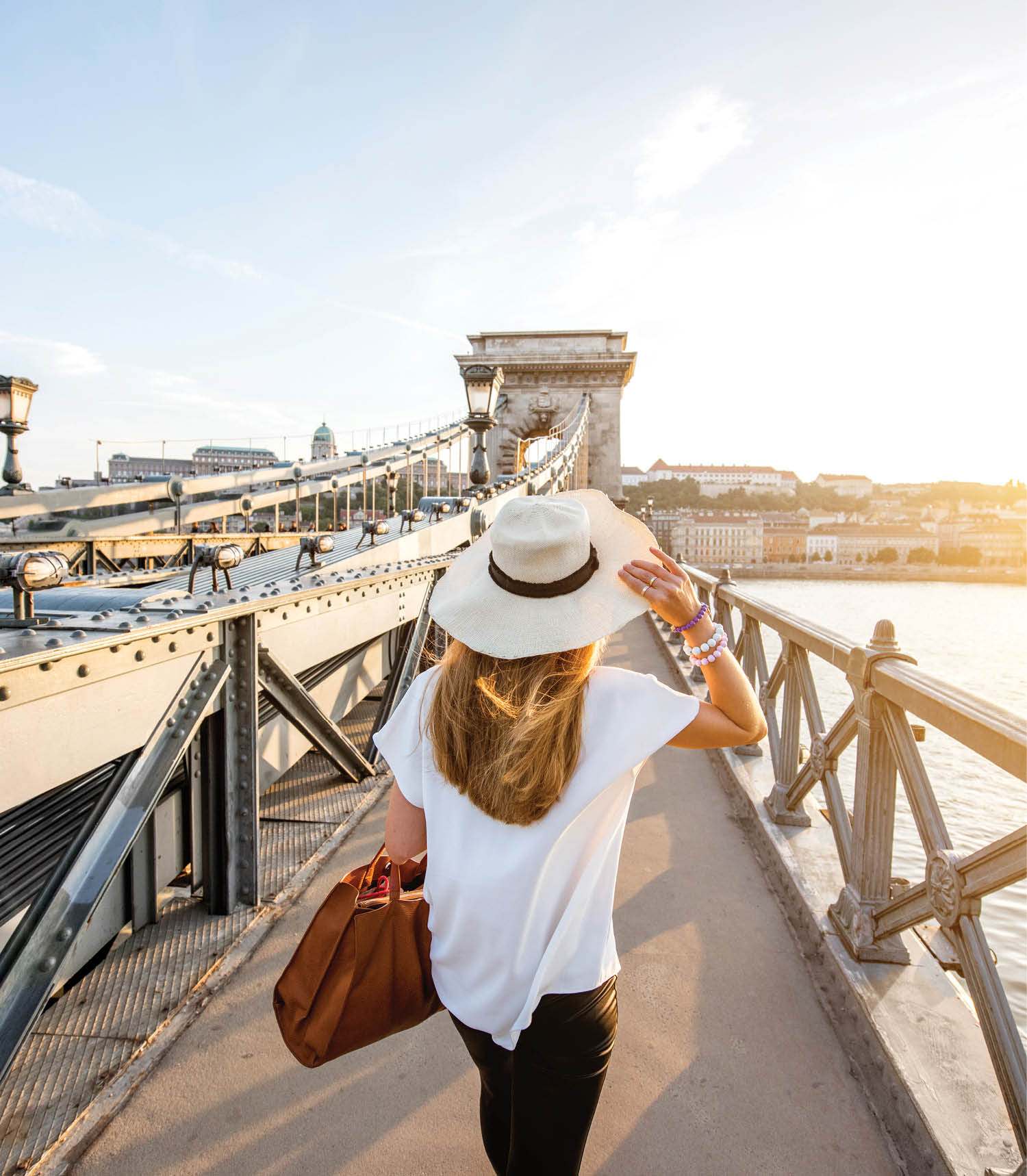 Young woman traveler walking on the famous Chain bridge during the sunset in budapest, Hungary