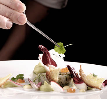 Male chef garnishing his dish, ready to serve