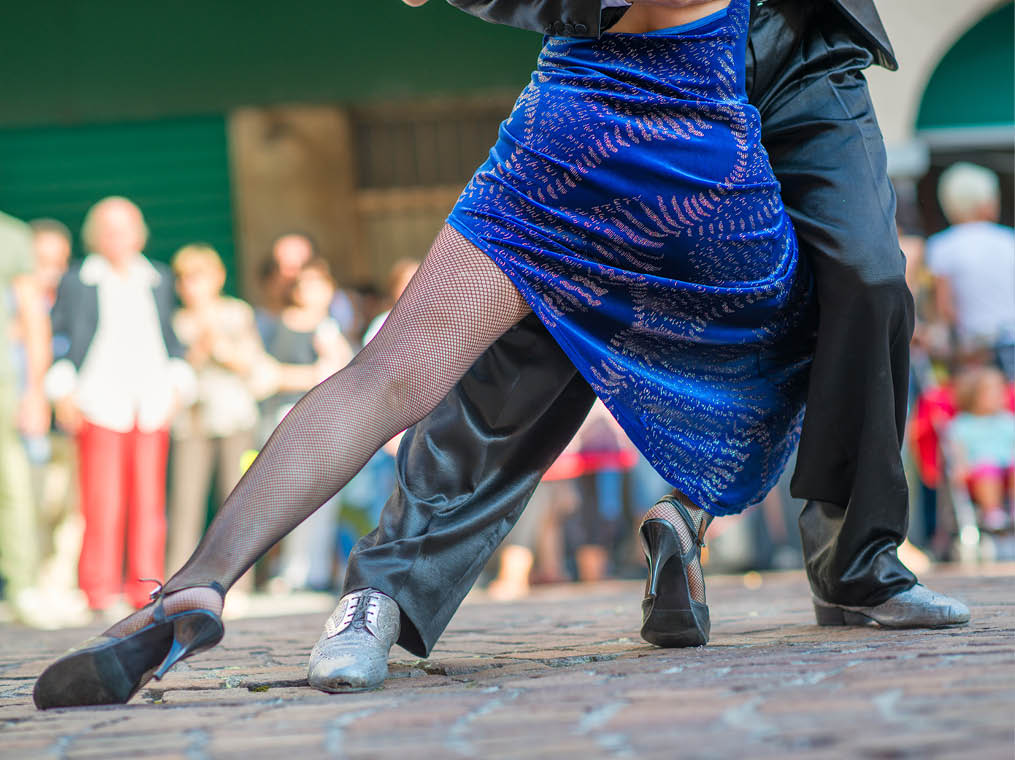 Couple dancing tango in the street among the people
