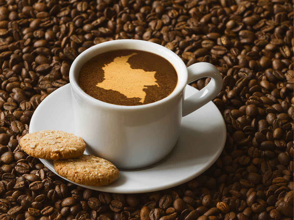 Still life photography of hot coffee beverage with map of Colombia