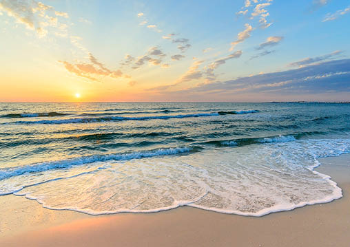 Long wave on the coast, dawn on the sea, Tunisia large foam waves in the sand, diagonal clouds, yellow light of dawn in the blue sky