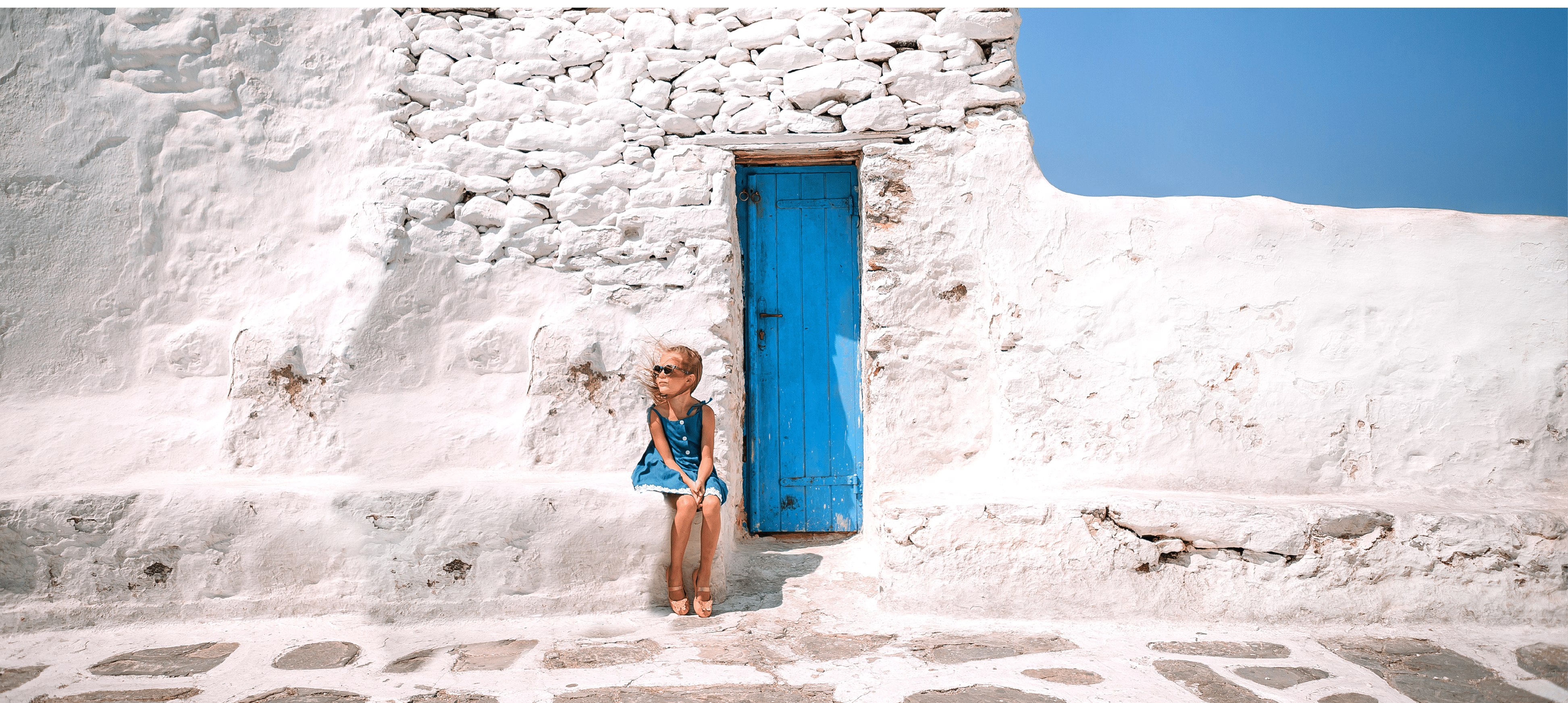 Family vacation in Europe  Parents and kids at street of typical greek traditional village on Mykonos Island, in Greece
