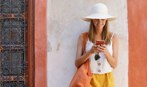 Stylish woman texting in traditional moroccan riad