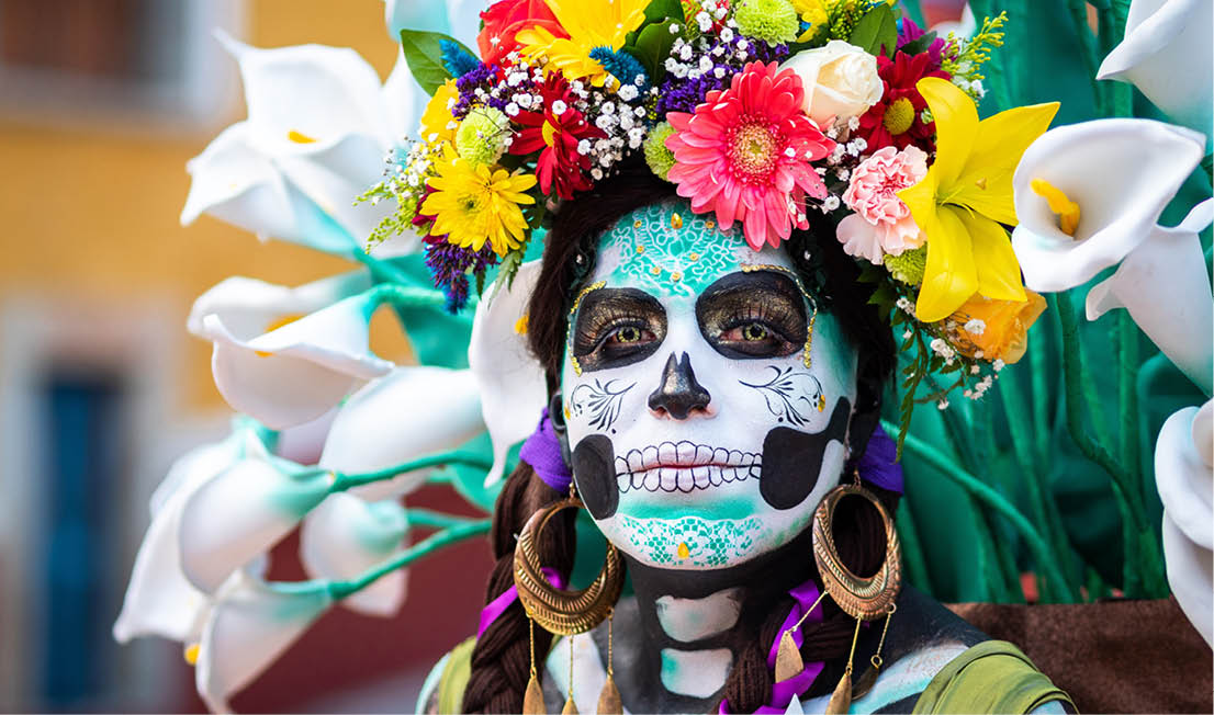 Guanajuato, Mexico - January 12, 2019: Portrait of a woman with beautiful Day of the Dead themed costumes and skull makeup on the streets of Guanajuato, Mexico 