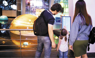 MOSCOW, RUSSIA - JULY 6: Exhibition in Moscow Planetarium  Motrher, father and little daughter looking at the exhibits of the one of the world s largest planetarium 