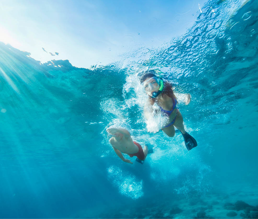 Snorkeling adventure. Best friends. Young man and woman, diving into the sea. Underwater turquoise lagoon. Happy teenage couple swimming, joy into the crystal clear sea. Mediterranean beach. Summer sea romance.