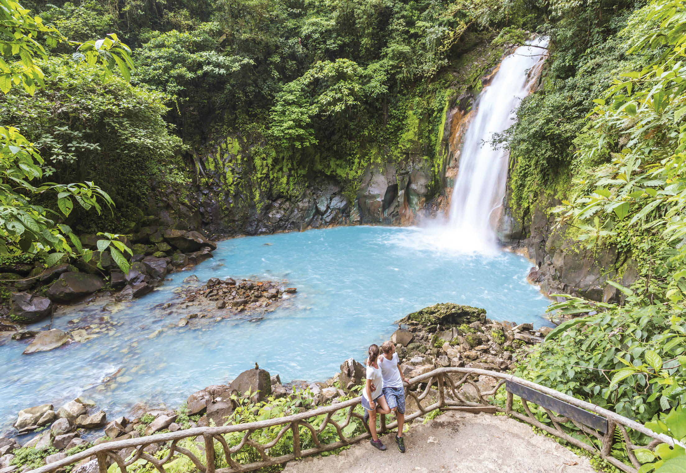 Tourist couple looking at Rio Celeste waterfall, Tenorio Volcano National Park, Guanacaste, Costa Rica