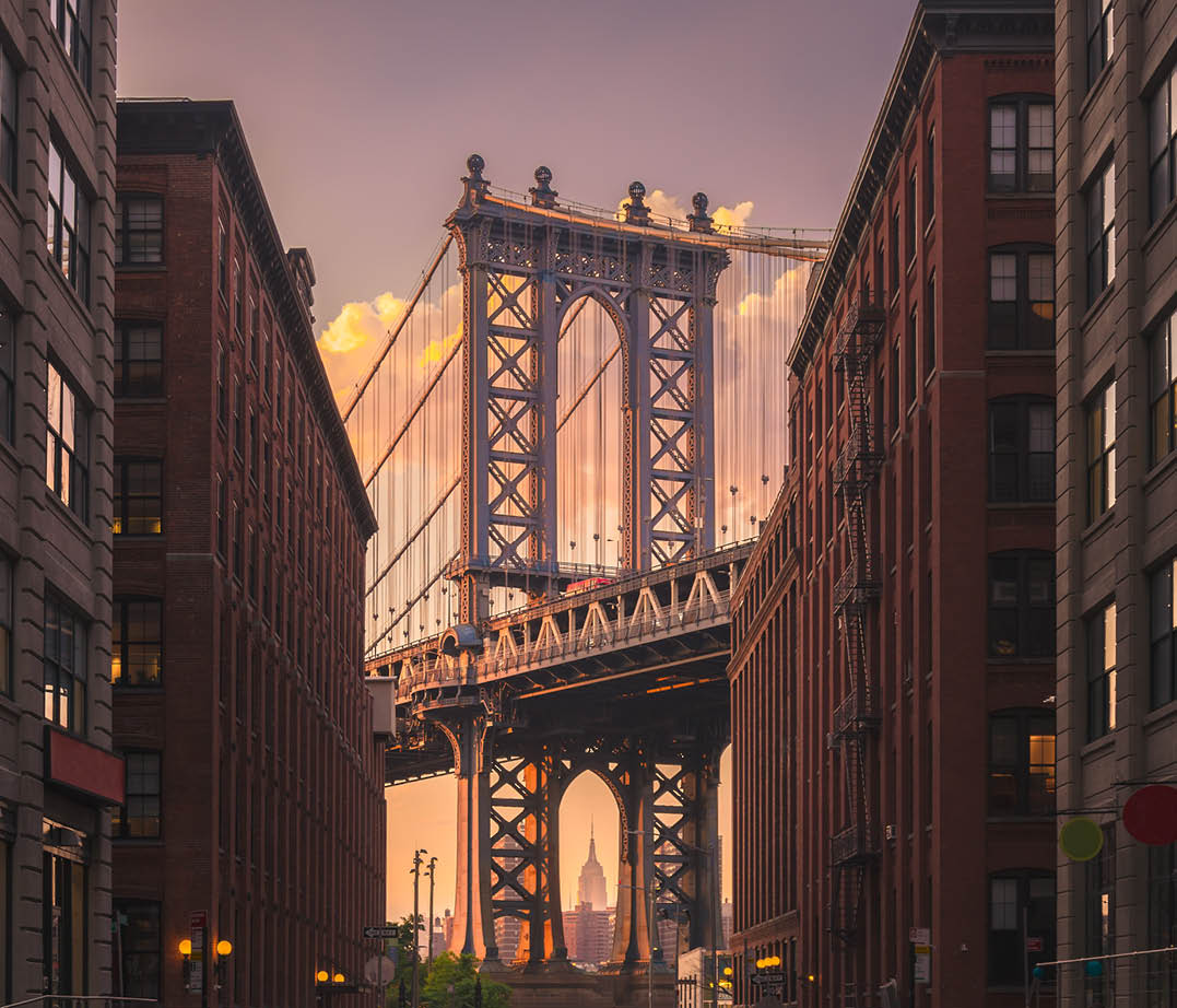 Manhattan bridge seen from a brick buildings in Brooklyn street in perspective, New York, USA  Shot in the evening