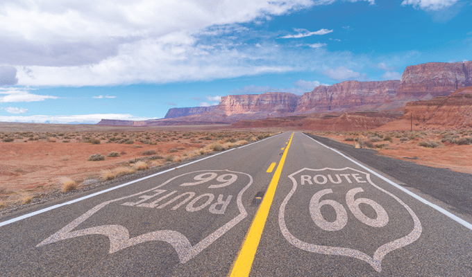 Route 66 sign on a scenic road to a mountain range in Arizona