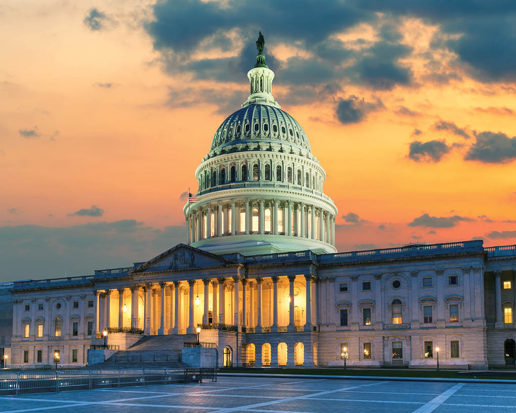 US Capitol Building at sunset with American flags is the home of the United States Congress in Washington D C, USA 