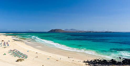 XXL panorama view of the islands of Lobos and Lanzarote seen from Corralejo Beach (Grandes Playas de Corralejo) on Fuerteventura, Canary Islands, Spain, Europe. Beautiful turquoise water & white sand.