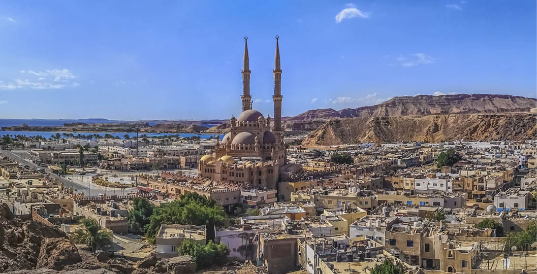 Widescreen panorama of the Old Market in Sharm El Sheikh with the Al Sahaba Mosque in the center and the Red Sea on the horizon. Aerial view of an Egyptian resort