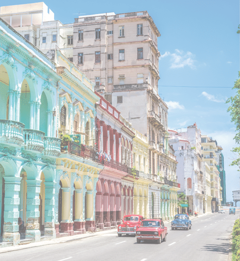 Old american classic cars on street of Havana against multicolored historic buildings