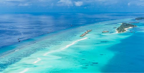 Aerial view on Maldives island, Ari atoll. Tropical islands and atolls in Maldives from aerial view. Summer vacation holiday landscape background.