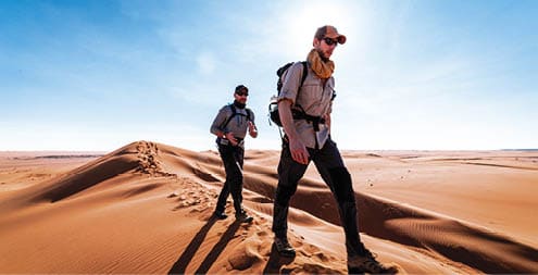Two men trekking the Wahiba deserts in Oman. 