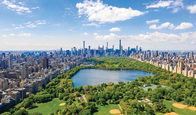 Aerial view of the Central park in New York with golf fields and tall skyscrapers surrounding the park.