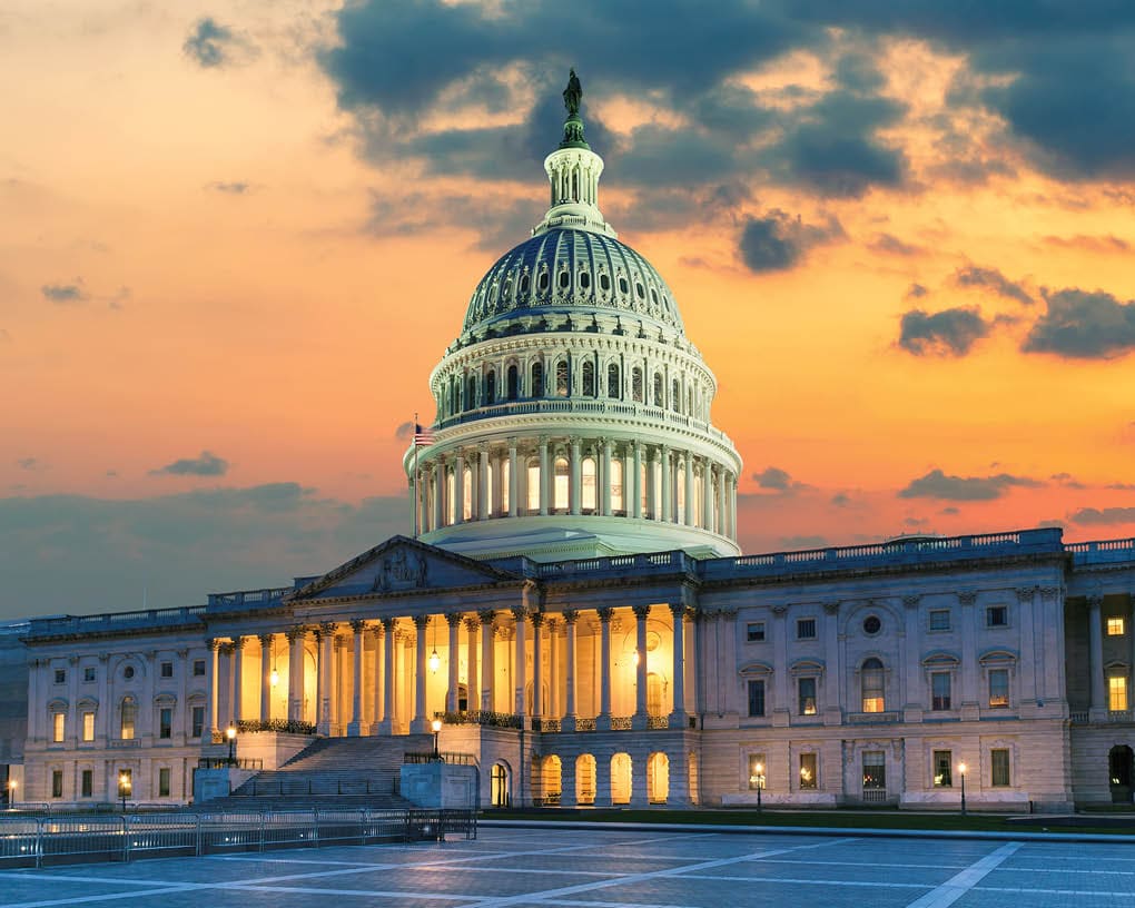 US Capitol Building at sunset with American flags is the home of the United States Congress in Washington D.C, USA.