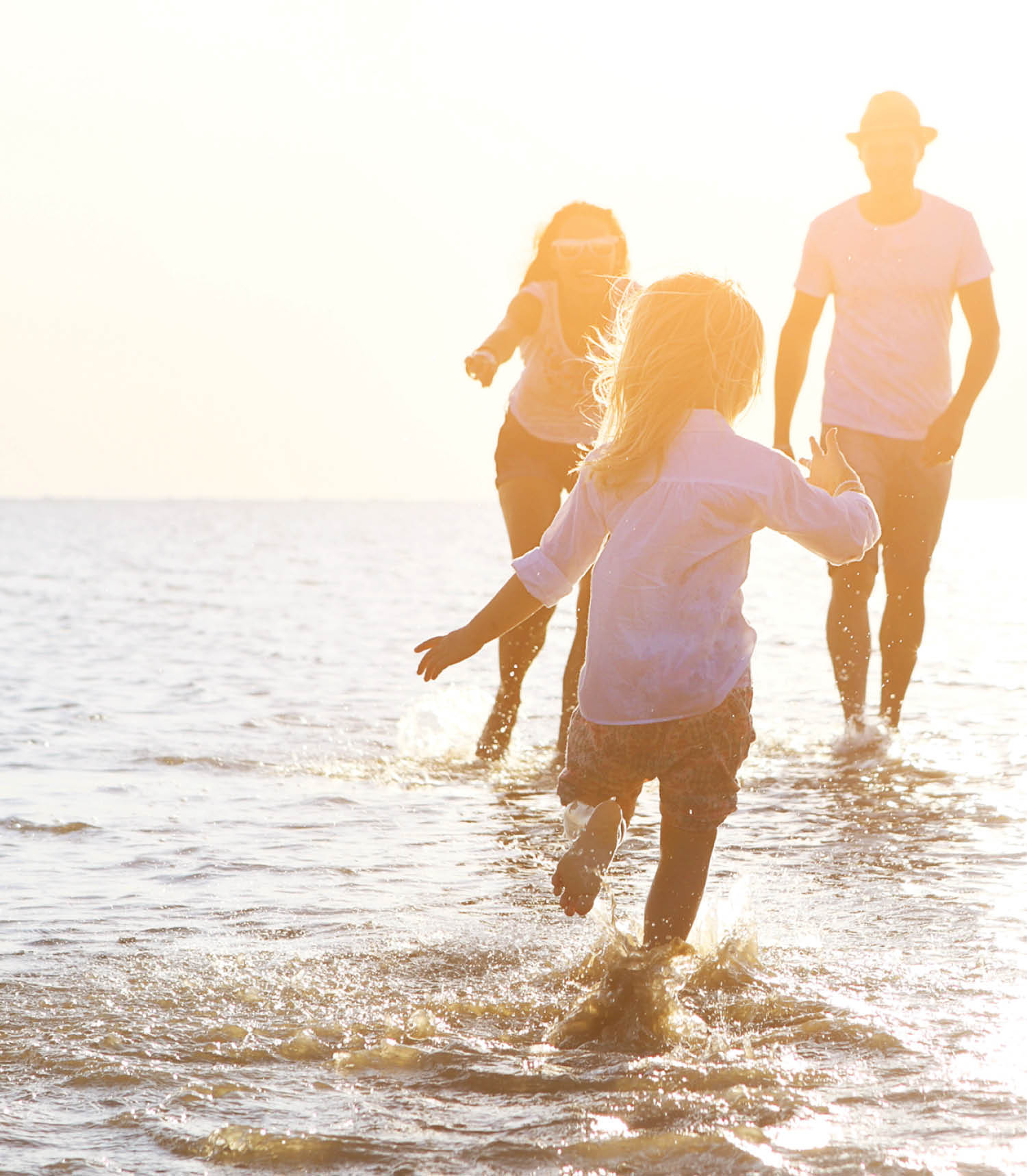 Happy young family having fun running on beach at sunset  Family traveling concept