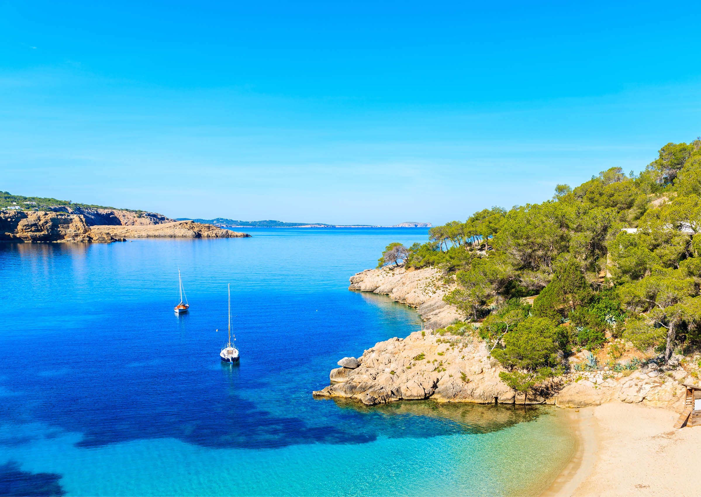 View of beautiful beach in Cala Salada famous for its azure crystal clear sea water, Ibiza island, Spain