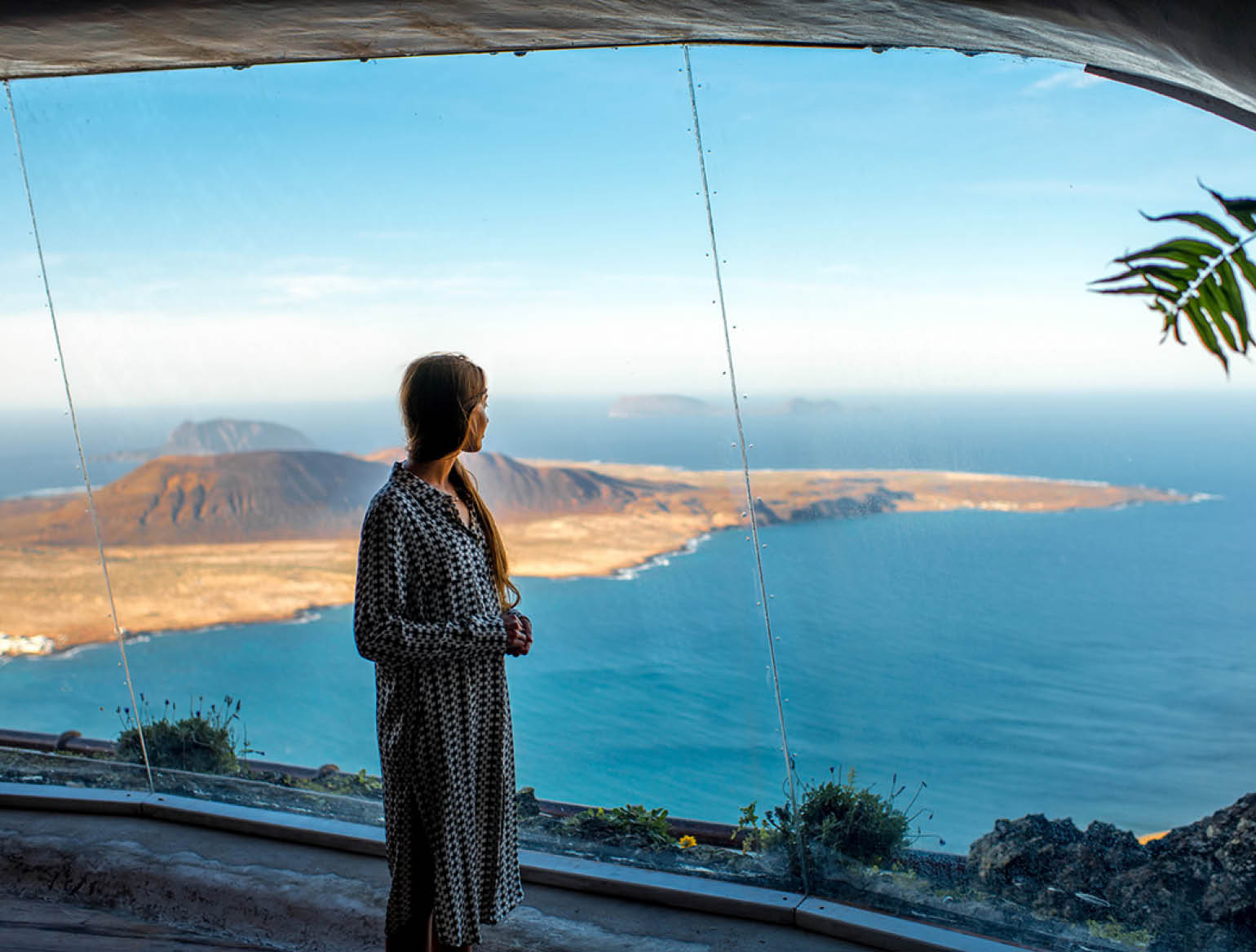 Woman looking on Graciosa island from El Rio viewpoint on Lanzarote island in Spain