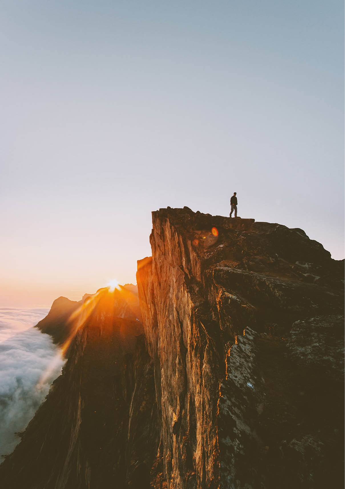 Traveler on cliff hiking alone sunset mountain adventure outdoor active vacations traveling lifestyle getaway