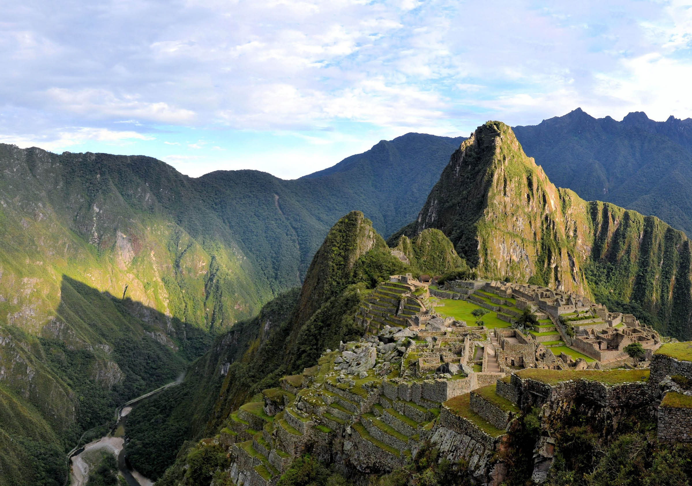 Panorama of Machu Picchu terraces, watcher's hut and Wuayna Picchu with shadow in early morning light  Machu Picchu is the famous lost city of the Incas near the river Urubamba located in the region of the sacred valley of Cuzco  Machu Picchu is a UNESCO world heritage site and one of the 7 new world wonders 