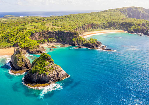 Beautiful aerial image of the hill two brothers in fernando de noronha brazil with blue sea, sand, sky, sun and clouds