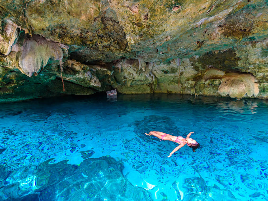 Cenote Dos Ojos in Quintana Roo, Mexico  People swimming and snorkeling in clear blue water  This cenote is located close to Tulum in Yucatan peninsula, Mexico 