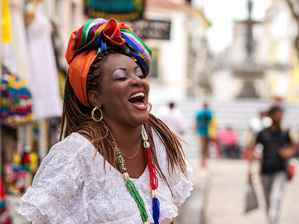Happy Brazilian woman of African descent dressed in traditional Baiana costumes in the Historic Center of Salvador da Bahia, Brazil 