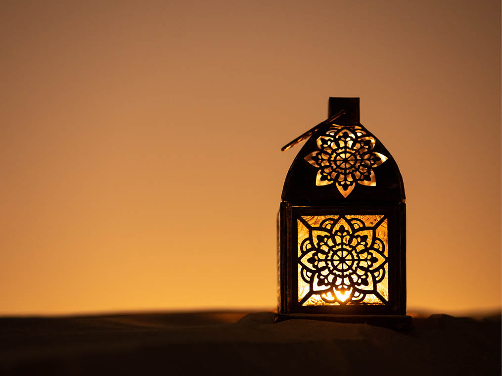 Traditional ornamental arabic lantern with a burning candle in desert after sunset during blue hour  Festivel greeting card for Ramadan Kareem and Ramadan Mubarak  Dubai, UAE 