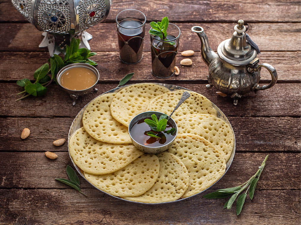 Moroccan breakfast with Baghrir, mint tea and honey, copy space 