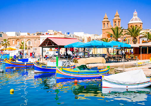 Malta  Traditional eyed colorful boats Luzzu in the Harbor of fishing village Marsaxlokk, Mediterranean Sea 
