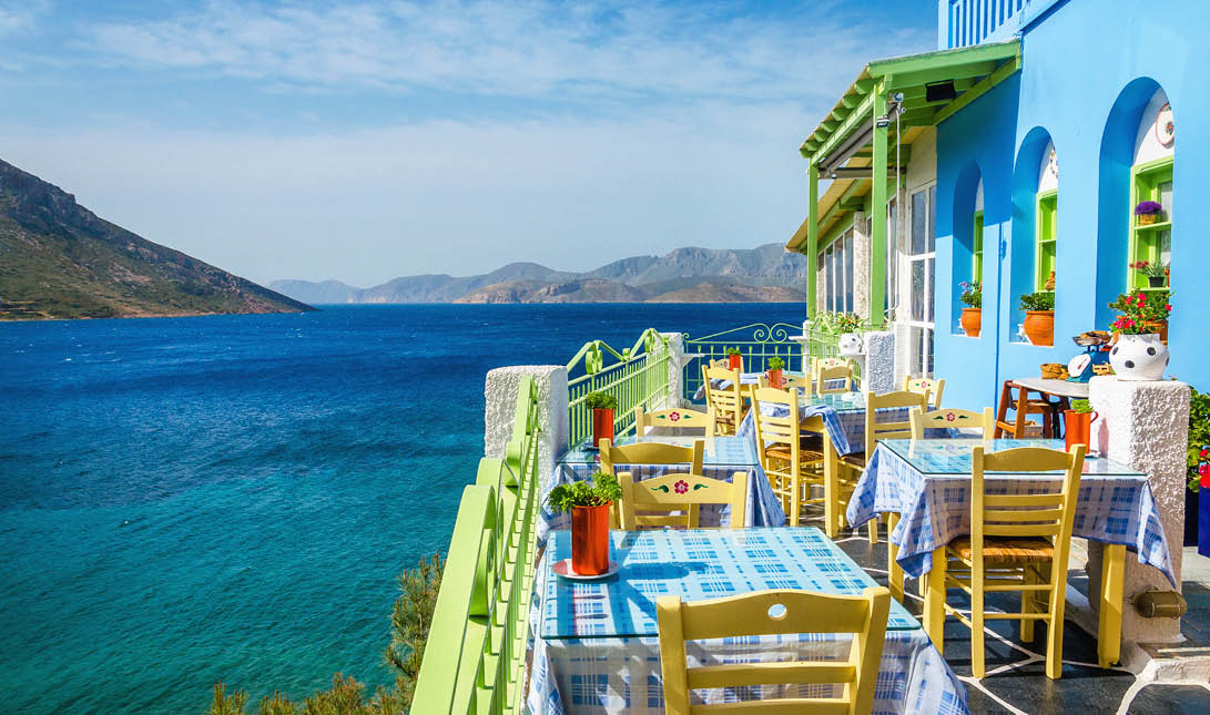  Typical Greek restaurant on the balcony blue building overlooking the sea, Greece