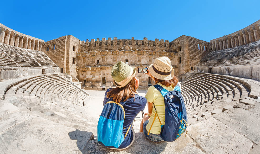 Two young girls student traveler taking selfie the ancient Greek amphitheater