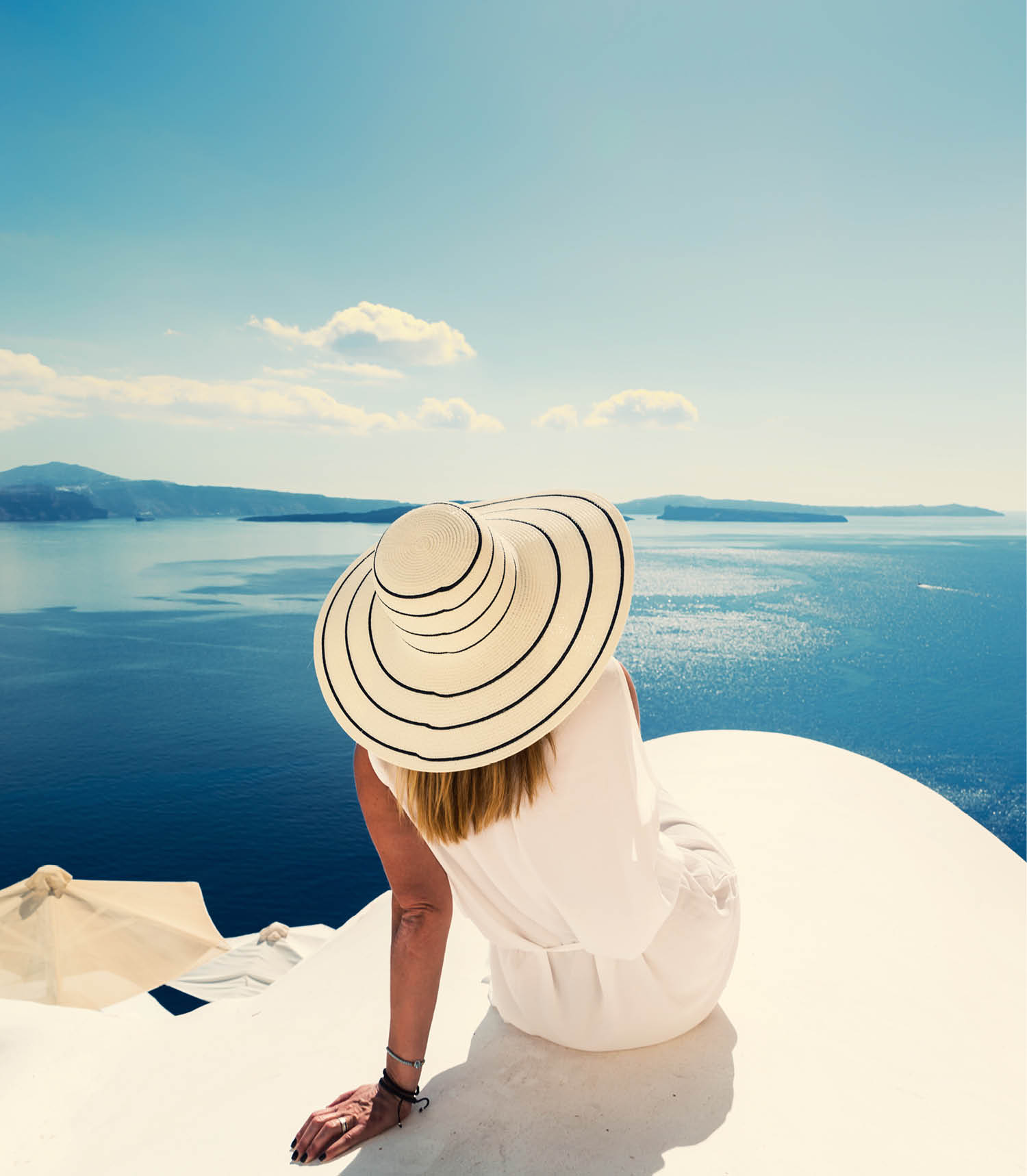 Luxury travel vacation woman looking at view on Santorini island in Greece  Amazing view of sea and Caldera 