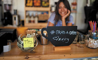 tips jar and grab sign for coffee at new open cafe  