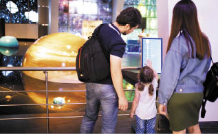 MOSCOW, RUSSIA - JULY 6: Exhibition in Moscow Planetarium  Motrher, father and little daughter looking at the exhibits of the one of the world s largest planetarium 